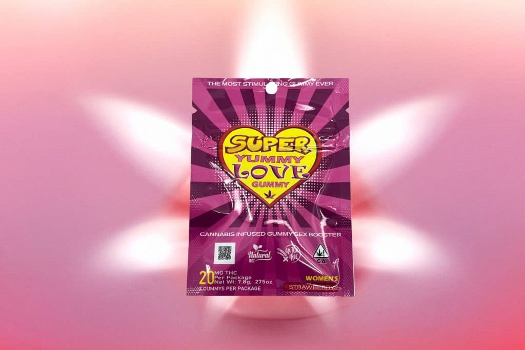 Super Yummy Love Gummy cannabis-infused edible in vibrant pink packaging with a heart design, placed against a soft pink glow background.