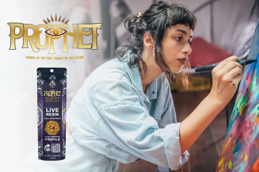 A focused artist in a denim shirt painting a colorful canvas, deeply immersed in creativity. The Prophet Quest Live Resin product is showcased on the left, with its premium packaging featuring gold and purple elements. The Prophet logo, with an all-seeing eye design, is prominently displayed at the top, reinforcing the brand’s theme of wisdom and vision.